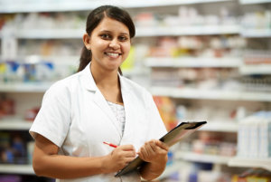 Cheerful pharmacist chemist woman standing in pharmacy drugstore