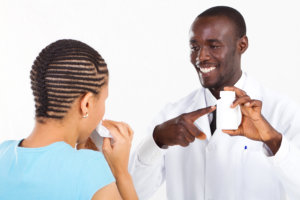 African american pharmacist explaining how to take the medicine to patient