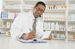 African American male pharmacist working in pharmacy