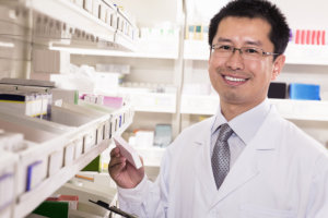 Pharmacist taking down and examining prescription medication in a pharmacy